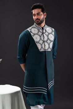 Peacock green sleeveless asymmetric bundi with bloom embroidery using pearls and beads. Paired with long sleeves plain kurta and matching churidar.
Components: 3
Pattern: Embroidered
Type Of Work: Pearl Bloom
Neckline: Band Collar
Sleeve Type: Bundi: Sleeveless, Kurta: Long
Fabric: Mal Cotton, Moss Crepe, Cotton Lycra
Color: Green
Other Details: 
Approx weight: 2kgs
Poly lining
Occasion: Mehendi and Puja, Sangeet - Aza Fashions Sleeveless Cotton Kurta For Eid, Sleeveless Cotton Kurta With Zari Work, Green Sleeveless Kurta With Resham Embroidery, Designer Sleeveless Kurta For Eid, Green Sleeveless Resham Embroidered Kurta, Designer Sleeveless Kurta For Transitional Season, Green Sleeveless Embroidered Traditional Wear, Sleeveless Green Traditional Designer Wear, Transitional Traditional Wear Sleeveless