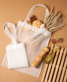 a white bag sitting on top of a wooden table next to some items that are in it