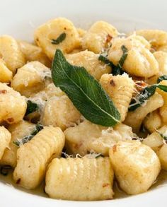 pasta with basil and parmesan cheese in a white bowl