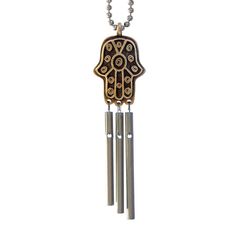 a wooden hamsa hanging from a chain with two metal bells on it's end