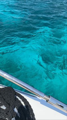 the water is crystal blue and there are rope on the boat's front end