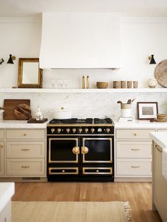 a stove top oven sitting inside of a kitchen next to white cabinets and counter tops