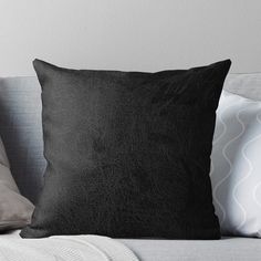 a black pillow sitting on top of a couch