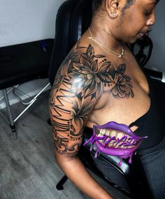 a woman with a tattoo on her arm and chest holding a purple object in her hand