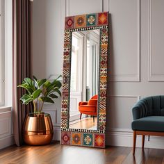 a mirror sitting on top of a wooden floor next to a chair and potted plant