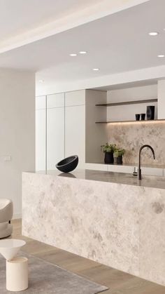 a modern kitchen with marble counter tops and white cabinets