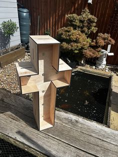 a cross made out of wood sitting on top of a wooden bench