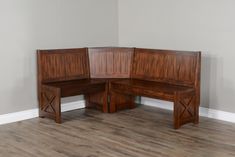 two wooden benches sitting on top of a hard wood floor next to a white wall