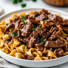 a bowl filled with beef and noodles on top of a table