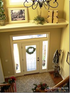 an overhead view of a foyer with christmas wreaths on the wall and pictures above it