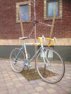 a blue bicycle parked next to a brick building