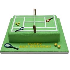 a green cake with tennis rackets and balls on it