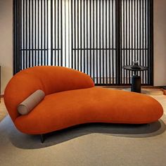 an orange couch sitting on top of a wooden floor