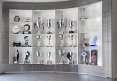 a display case filled with lots of trophy cups and trophies on shelves next to each other