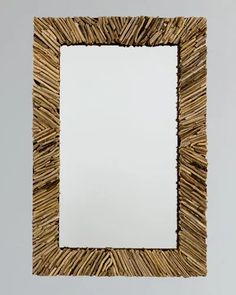 a square mirror made out of straw sticks