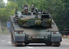 an army tank is driving down the road