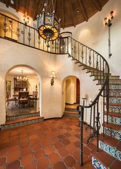 a staircase leading to the second floor in a home with tile floors and walls, along with an arched doorway