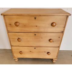 a wooden chest of drawers sitting on top of a hard wood floor