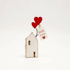 a small house with two hearts attached to it and a sign that says with love