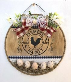 a wooden sign hanging on the side of a wall with eggs in front of it