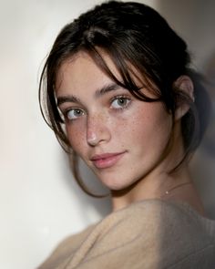 a woman with freckled hair is posing for the camera