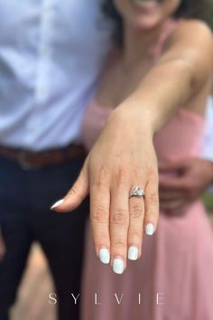 a man and woman standing next to each other with their wedding rings on their fingers