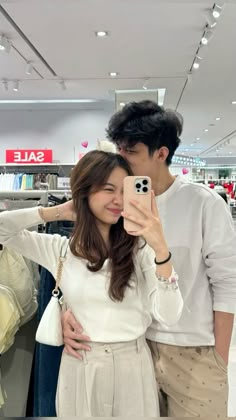 a man and woman taking a selfie in a store