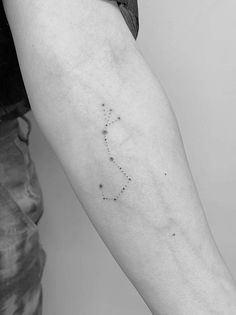 a woman's arm with a small star tattoo on the left side of her arm