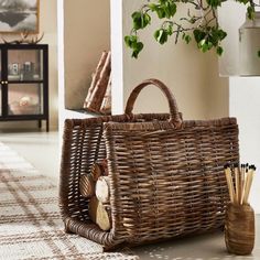 a wicker basket sitting on the floor next to a potted plant