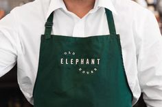 a man wearing an apron with the words elephant house on it's front pocket