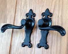 two black door handles on a wooden surface