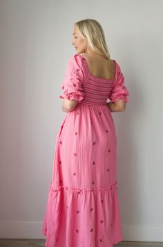 Discover a perfect blend of style and comfort with our Embroidered Gauze Midi Dress in Pink. The lightweight gauze fabric is adorned with delicate floral embroidery and a bold dark pink contrast, making it perfect for any occasion. The smocked waist adds a flattering fit and the midi length offers versatility for all body types. Embrace the hot pink hue and make a statement with this beautiful dress. gauzy cotton smocked bodice elbow length sleeves side pockets embroidered lined midi/maxi length Pink Short Sleeve Embroidered Dress For Spring, Feminine Midi Length Embroidered Dress With Floral Details, Feminine Midi-length Embroidered Dress With Floral Embroidery, Feminine Embroidered Midi Dress For Spring, Feminine Embroidered Fitted Maxi Dress, Feminine Fitted Embroidered Maxi Dress, Spring Feminine Embroidered Dress, Feminine Spring Embroidered Dress, Spring Pink Midi Dress With Floral Embroidery