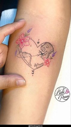 a woman's arm with a tattoo on it that has flowers in the shape of a heart