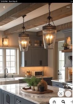 a kitchen with two lights hanging from the ceiling and an island in front of it