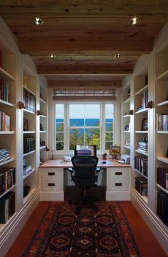 a home office with lots of bookshelves and a rug on the floor in front of it