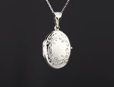 "Carrying the pictures of your loved ones close to your heart all the time, this personalized locket necklace features: 1. an oval solid sterling silver locket (1 x 3/4\", 4.6 grams) that can hold two pictures. It has a pretty bordered front stamped in a floral pattern Its back can be engraved (use pulldown menu to select) complicated graphics / handwriting /fingerprints will incur surcharge Photo insertion service available at $14 each photo. If you select it from the pulldown menu, please foll Luxury Silver Medallion Locket Necklace, Circle Locket, Silver Locket Necklace Vintage, Oval Locket Necklace Silver, Personalized White Locket Jewelry, Stamped 925 Round Pendant Keepsake Jewelry, White Locket Jewelry For Personalized Gifts, Oval White Gold Locket Necklace For Wedding, White Gold Oval Locket Necklace For Wedding