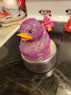 a pink rubber ducky sitting on top of a sink next to other bath toys