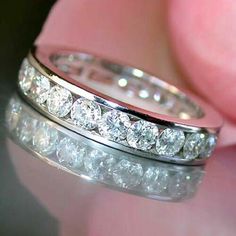 a close up view of a wedding ring with diamonds