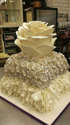 a cake made to look like flowers with ruffles on the bottom and sides