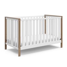 a white crib with wood trims on the sides and bottom rail, in front of a white background