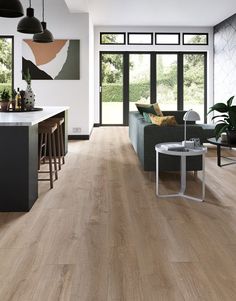 a living room filled with furniture next to a kitchen and an open floorplan