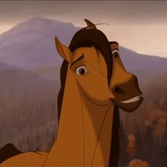 the horse is standing in front of a mountain and has his head turned to look like he's smiling