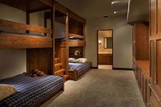 a bedroom with bunk beds and wooden cabinets