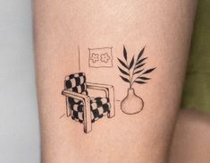 a tattoo on the leg of a woman with a chair and potted plant