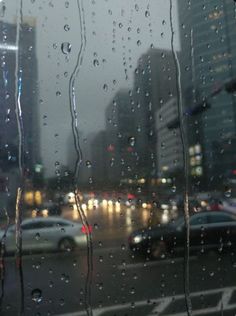 rain drops on the window as cars drive by