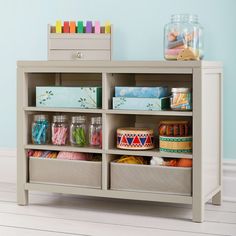 a shelf filled with craft supplies on top of a wooden floor