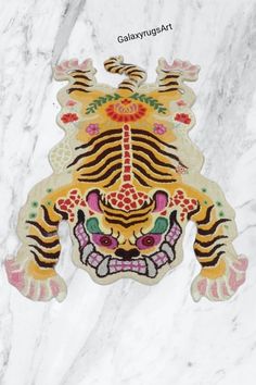 a white marble floor with a tiger design on it's face and colorful flowers