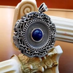 This impressive pendant is made of oxidized pure silver 925. The center of it is decorated with a genuine round Lapis Lazuli stone. It is a really eye catching pendant. The big open bale allows you to have the pendant with your favorite thick chain or cord. Dimensions : Pendant : 5cm, with bale 6.3cm Lapis : 12mm For more Byzantine designs visit : https://www.etsy.com/shop/YianniJewellery Silver Byzantine Ceremonial Jewelry, Silver Byzantine Jewelry For Ceremonies, Ceremonial Byzantine Silver Jewelry, Silver Byzantine Gemstone Jewelry, Silver Byzantine Jewelry As A Gift, Byzantine Sterling Silver Hallmarked Jewelry, Byzantine Hallmarked Sterling Silver Jewelry, Byzantine Style Hallmarked Sterling Silver Jewelry, Hallmarked Byzantine Sterling Silver Jewelry