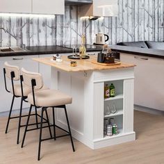 a kitchen island with three chairs in front of it