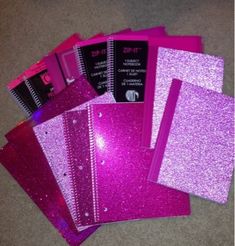 purple glitter notebooks and binders on the floor